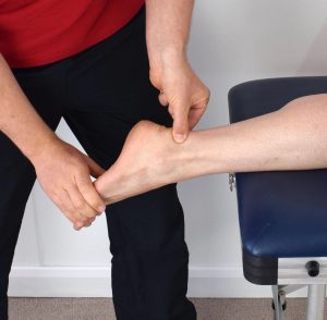 rehabilitation-in-physiotherapy rehabilition in physiotherapy post surgery where a physiotherapist helps a patient with their ankle after surgery